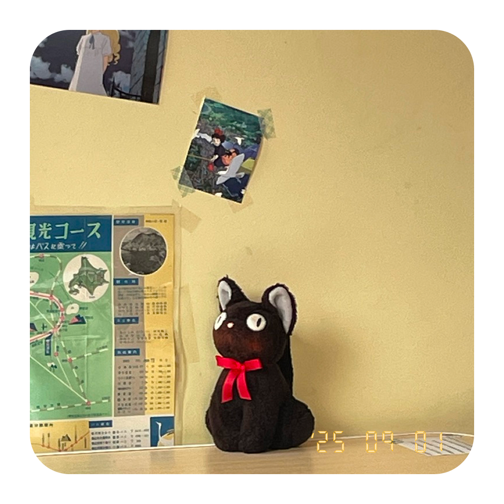 Névo widget showing a photo of a small black doll with red ribbon against a yellow wall